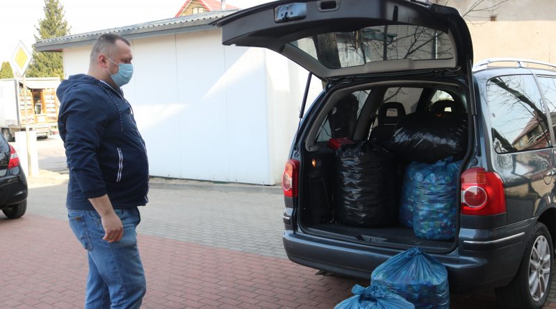 Pan Zbigniew, tata 6-letniego Igorka Kamińskiego stoi przy samochodzie z otwartym bagażnikiem, do którego zapakowane zostały worki z nakrętkami zebranymi w Filipowie. Przy samochodzie stoją jeszcze dwa pełne worki nakrętek.