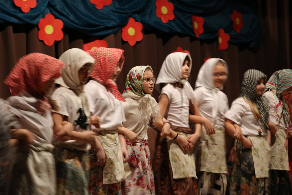 Uczestniczki Koła Teatralnego GOKiS, trzymające się pod rączki, przebrane za babuszki w swoim przedstawieniu.